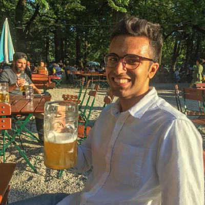 Shiv, smiling, at an outdoor beer garden